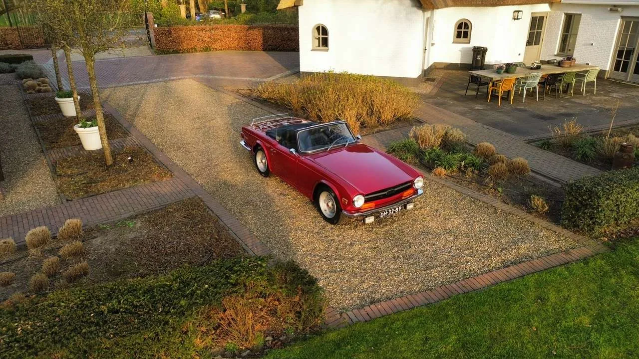 Triumph TR6 Mimosa Yellow de trois quarts avant, roadster anglais musclé carrosserie Karmann, roues de 15 pouces